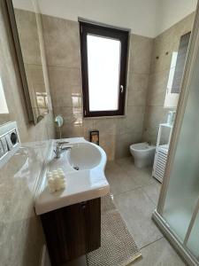 bagno con lavandino, finestra e doccia di Garden House a Bellizzi