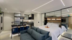 um quarto com uma cama, um sofá e uma cozinha em Apartamento na paulista (com garagem) em São Paulo