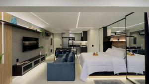 1 dormitorio con 1 cama grande y 1 sofá azul en Apartamento na paulista (com garagem) en São Paulo