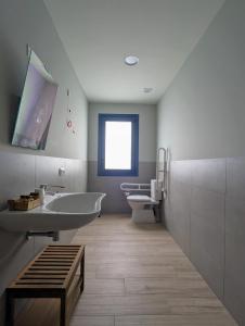 ein Badezimmer mit einer Badewanne, einem Waschbecken und einem WC in der Unterkunft Restaurante Hostal Náutico de Razo in Carballo