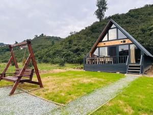 a small cabin with a swing and a house at Hanifta Bungalows in Trabzon
