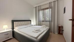 1 dormitorio con 1 cama grande y toallas. en Gemütliches Haus im Herzen Albaniens, en Elbasan
