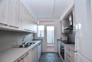een keuken met een wastafel en een koelkast bij Santa Maria apartment in Vilassar de Mar