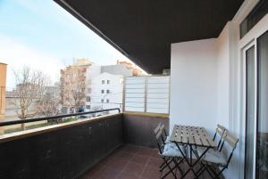 een balkon met 2 stoelen, een tafel en een raam bij Santa Maria apartment in Vilassar de Mar