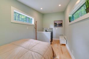 - une chambre avec un grand lit et 2 fenêtres dans l'établissement Secluded Upstate NY Forest Cottage on 33 and Acres!, à Oneonta