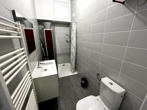 a bathroom with a white toilet and a sink at Logements situés en plein cœur de ville avec jardin in Rochefort