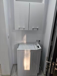 einen kleinen weißen Kühlschrank in einem Zimmer mit einem Schrank in der Unterkunft APARTAMENT 12 RO&MARIO BARLAD in Bîrlad