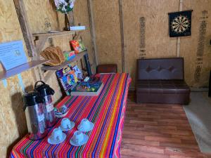 a room with a table with a colorful table cloth at Soraypampa Hostel - Private Cabins & Dorms for Self-Guided Humantay & Salkantay Trek -Comidas-hot shower-wifi-Pack horses in Salcantay