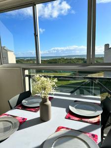 a dining table with a view of the ocean at Bella Casa - Seaview-Beach Club Apartment in Cape Town