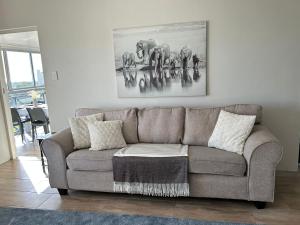 a living room with a couch and a painting of elephants at Bella Casa - Seaview-Beach Club Apartment in Cape Town