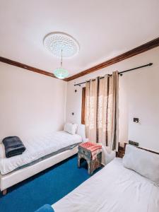 a bedroom with two beds and a table at Gite Panorama in Imlil