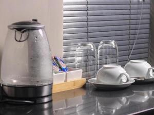 un mixeur assis sur un comptoir avec deux tasses et des assiettes dans l'établissement @ 21 Guest House, à Pietermaritzburg