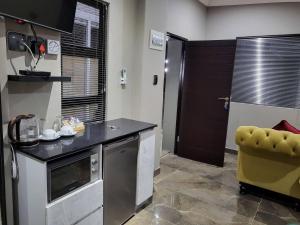 a kitchen with a counter and a yellow chair at @ 21 Guest House in Pietermaritzburg