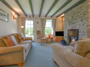 a living room with two couches and a fireplace at Primrose Cottage in Wadebridge