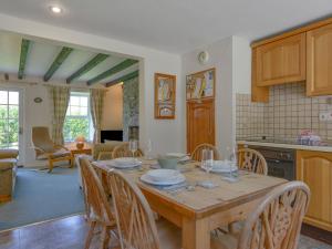 a kitchen and dining room with a wooden table and chairs at Primrose Cottage in Wadebridge