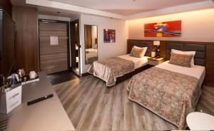 a hotel room with two beds and a television at CITY ASYA HOTEL in Bandırma
