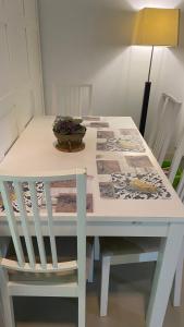 un tavolo bianco con una sedia e una ciotola di fiori di Manzanas a Camarma de Esteruelas