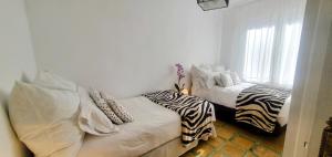 Habitación con 2 camas con almohadas de cebra. en LA CASILLA en Cájar