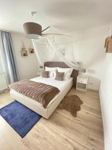 a bedroom with a white bed and a blue rug at Harzperle 3 II zentrales 3 Zi Apartment II Familien in Bad Harzburg