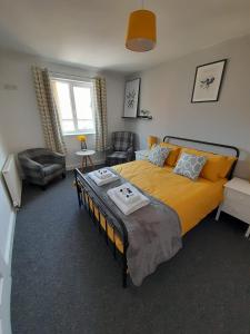 a bedroom with a large yellow bed and a chair at Church House in Gainsborough