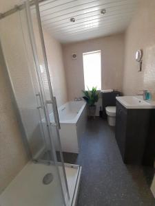 a bathroom with a tub and a toilet and a sink at Church House in Gainsborough