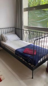 a metal bunk bed with a blue blanket and a window at Manzanas in Camarma de Esteruelas