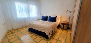 a bedroom with a bed with blue pillows on it at LA CASILLA in Cájar