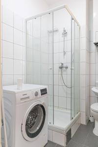 La salle de bains est pourvue d'un lave-linge et d'une douche. dans l'établissement Spacious 2BR Apt Great Location - Near Schönbrunn, à Vienne
