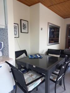 une salle à manger avec une table et des chaises noires dans l'établissement Casa do Portão Azul - Espadarte, à Atouguia da Baleia