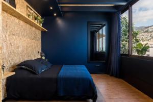 Un dormitorio azul con una cama y una ventana. en SUPER Central - Deep Blue, en Funchal