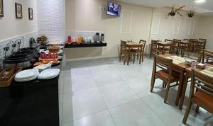 a restaurant with a counter and tables and chairs at Pousada Dubai in Itabuna +10 photos
