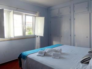 een slaapkamer met een bed met twee handdoeken erop bij Casa do Portão Azul - Espadarte in Atouguia da Baleia