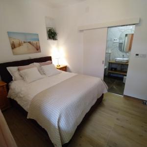 ein Schlafzimmer mit einem Bett und ein Badezimmer mit einem Waschbecken in der Unterkunft Relax oasis near Split in Vranjic