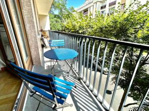 2 blaue Stühle und ein Tisch auf dem Balkon in der Unterkunft Lumineux 2 pièces Paris nord-est in Pantin