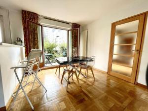 ein Esszimmer mit einem Tisch, Stühlen und einem Fenster in der Unterkunft Lumineux 2 pièces Paris nord-est in Pantin
