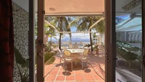 an open door to a patio with a table and chairs at Sunset Beach Resort in Moalboal