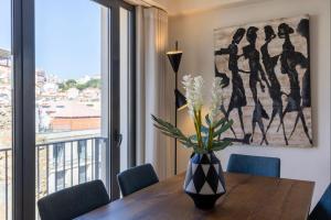 - une table à manger avec un vase de fleurs dans l'établissement LovelyStay - Breathtaking Panorama - Luxurious Penthouse!, à Lisbonne