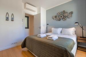 リスボンにあるLovelyStay - Breathtaking Panorama - Luxurious Penthouse!のベッドルーム1室(大型ベッド1台、タオル2枚付)