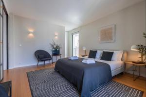 - une chambre avec un lit et une chaise dans l'établissement LovelyStay - Breathtaking Panorama - Luxurious Penthouse!, à Lisbonne