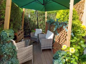 una terrazza in legno con sedie e ombrellone di East Claremont Guest House a Edimburgo