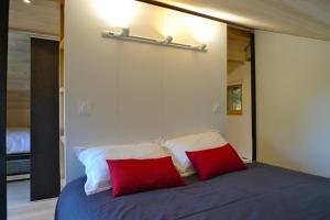 a bedroom with a bed with two red pillows at Chalet*** au pied d'une prairie face à la montagne in Sixt