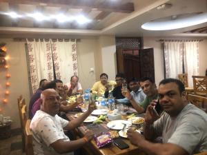 een groep mensen die rond een tafel zitten bij The Exotic House in Kathmandu