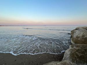 una spiaggia con costa rocciosa e l'oceano di [Chi Ama il Mare] Appartamento a Latina