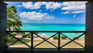 uma vista para o oceano a partir de uma janela em Hawksbill Resort Antigua - All Inclusive em Five Islands Village