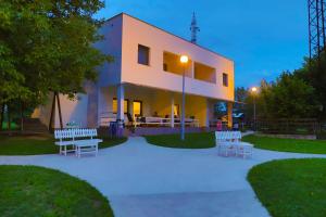 a building with tables and benches in front of it at Holiday Homes Pozitiva in Bihać