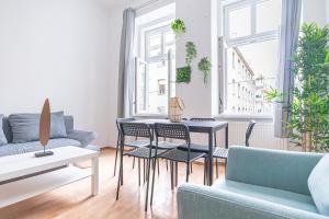 a living room with a table and chairs and a couch at Breathtaking 2BR Apt Modern Design/Near Schönnbrunn in Vienna