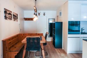 uma cozinha com uma mesa de madeira e um frigorífico azul em Bündapark em Davos