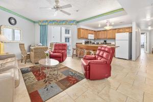 a living room with red chairs and a kitchen at Luxury 15th Floor 2 BR Condo Direct Oceanfront Wyndham Ocean Walk Resort Daytona Beach | 1501 in Daytona Beach