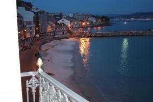 - Balcón con vistas a la playa por la noche en Apartmentos Vistamar Galicia Raxó, en Raxó