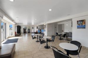 a room with tables and chairs and a kitchen at Motel 6-Bryan, TX - University Area in Bryan